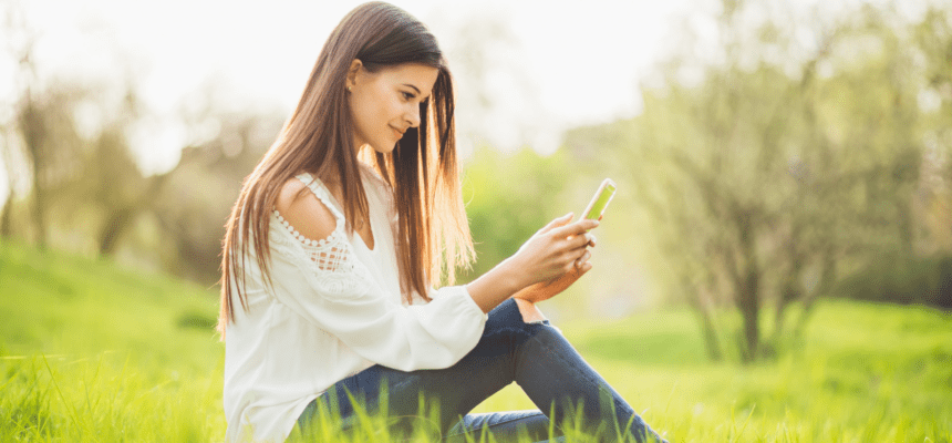 Girl on smartphone in Spring countryside